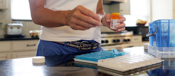 A photo of a woman organizing pills.